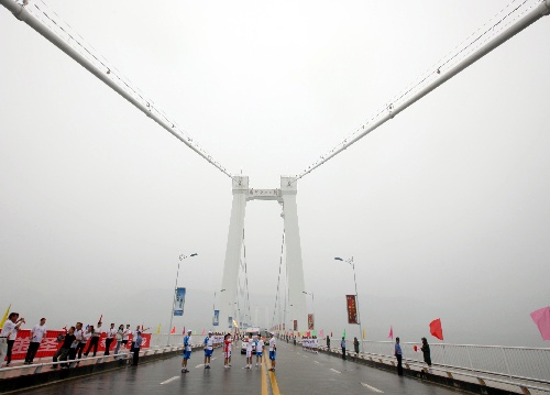 图文:圣火重庆万州传递 火炬手在长江二桥交接