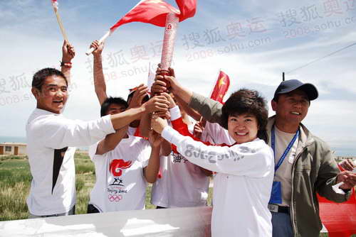 组图：圣火在青海湖传递 火炬手与民众分享喜悦