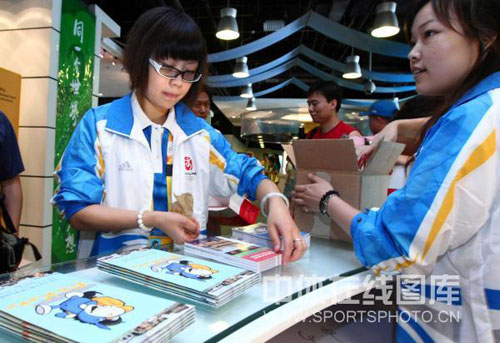 图为北京奥运会新闻中心里志愿者正忙碌的整理着相关材料.