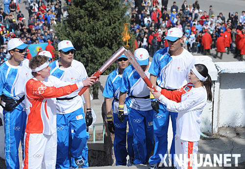 资料图片：4月2日，北京奥运会圣火传递活动在哈萨克斯坦阿拉木图市进行，这是奥运火炬手、哈萨克斯坦游泳运动员拉博塔（前左）与火炬手扎米利亚进行火炬交接。新华社记者安治平摄