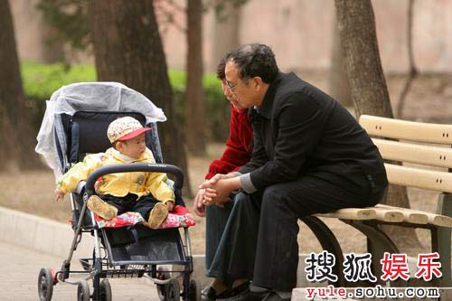 一对老人和小孙子在公园溜早