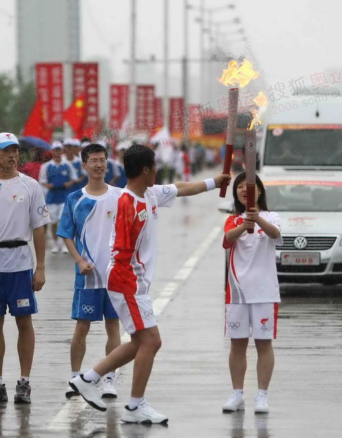 组图:圣火在延吉传递 独臂火炬手雨中擎"祥云"