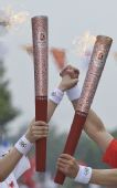 图文：奥运圣火在济南传递 两名火炬手在交接