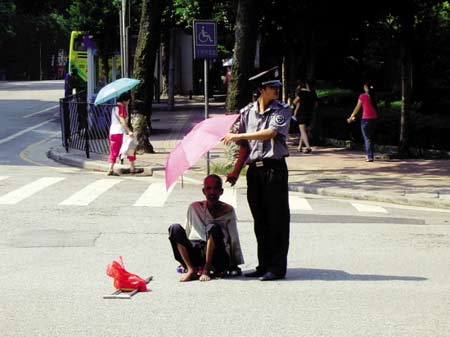 老人顶烈日过马路 好心保安撑伞挡日步步停(图