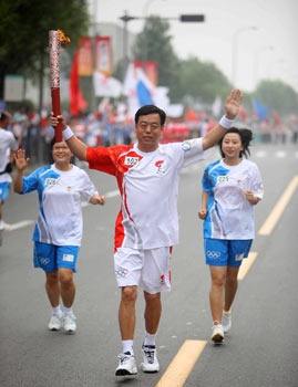 8月1日，火炬手曲敬东在进行传递。当日，北京奥运圣火在天津市传递。新华社记者邢广利摄