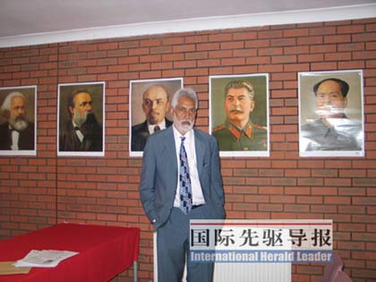 英国马列主义共产党主席布拉尔站在会议室里，后头的墙上依次贴着马克思、恩格斯、列宁、斯大林和毛泽东的画像。马桂花/摄