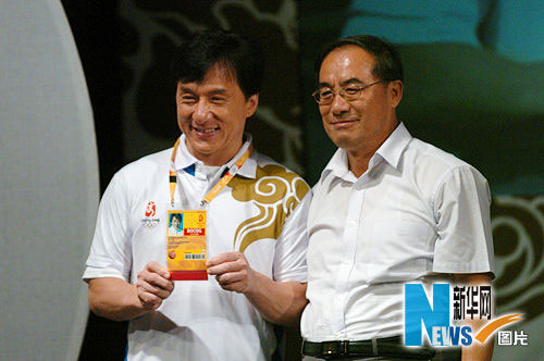 成龙向观众展示他的奥运会志愿者注册卡