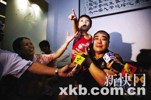 冼东妹夺冠后，丈夫刘波抱着一岁零7个月的女儿对着电视喜极而泣。图片/新快报记者 夏世炎 陈昆仑