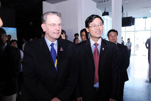 联想集团董事局主席杨元庆(右)陪同罗格(左)参观联想数字奥运体验馆