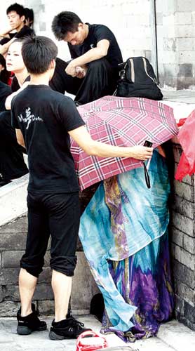 女演员让同伴拿雨伞为自己搭起临时更衣室