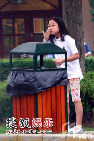 小龙女站在垃圾桶旁边吃东西