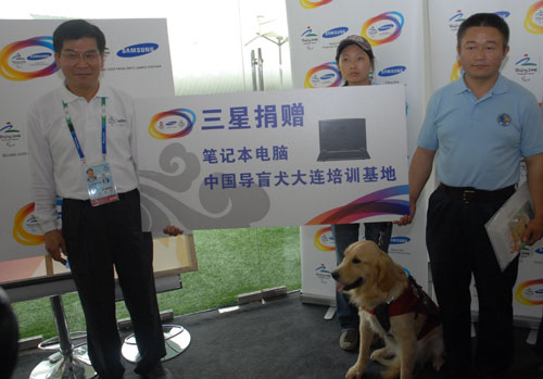 三星电子体育营销执行总监李永国在三星奥运宣传馆向大连导盲训练中心捐赠电子产品