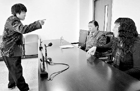 李芳（右）及其母亲坐在了原告席上，来到法庭的丈夫王军（左）则背对着妻子 摄/记者杨威