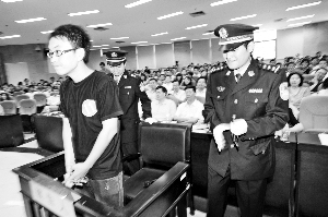华南理工大学的模拟法庭吸引不少同学旁听，“许霆”被押上“法庭”时，“法警”同学忍不住笑了。信息时报记者 巢晓 摄