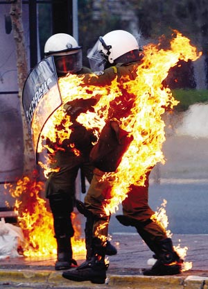 防暴警察因为被示威者投掷的燃烧弹击中而全身着火.