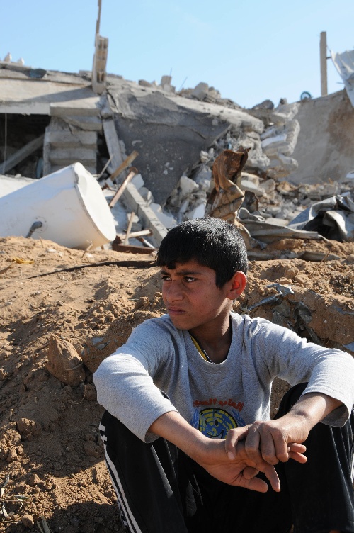 图文:巴勒斯坦儿童坐在被战争毁坏的废墟中