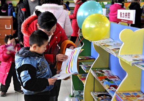 图文:一名家长带着孩子在新华书店选购图书