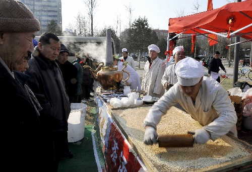 图文:市民在参观传统小吃麻饼的制作