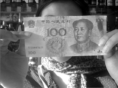 陈小姐展示收到的“TJ38”打头的百元假钞 海南特区报供图