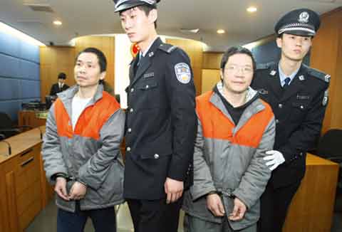被告人胡汉成(右二)和任和生(左一)被带进法庭