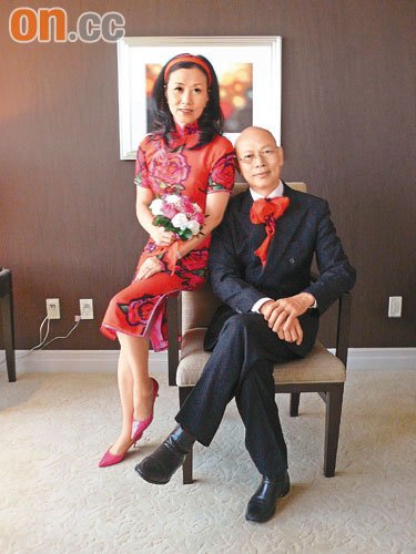 身穿红色旗袍的汪明荃与罗家英拍下婚照，与大众分享喜悦