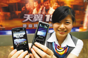 昨日，大坪电信营业厅，工作人员展示新上市的3G手机。本报记者 张锦旗 摄