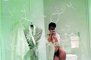 这是其中一张照片，蕾哈娜身着比基尼在浴室中对着镜子自拍