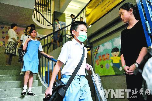 6月11日,香港北角一家小学的学生戴着口罩离开学校■供图/新华