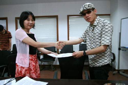 脑浊乐队主唱肖容先生与上海超音公司总裁朱女士握手示意，祝合作愉快