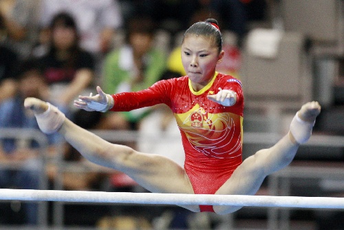 7月18日,中国队队员何可欣在女子团体高低杠比赛中角逐