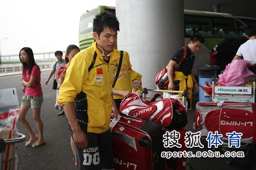 图文：中国羽毛球队载誉归来 林丹搬运行李