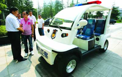 9月10日，大学城重庆师范大学新校区，张航（前右）将电瓶巡逻车赠送给学校保卫处 记者 龙在全 摄