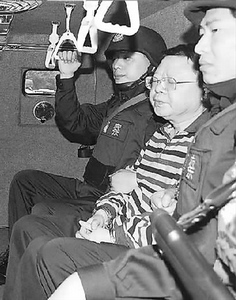 文强(中)日前被执行逮捕，图为正在送转途中(9月26日摄)。