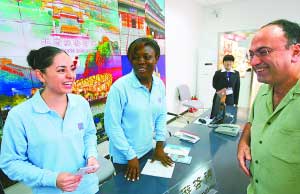 上图：昨天，两名外籍志愿者在王府井旅游咨询站为游客服务。