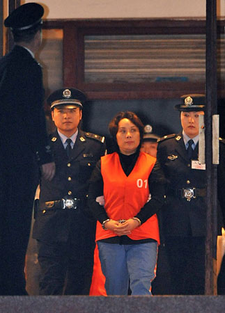 10月15日22时许，谢才萍（右二）被押解走出法庭。