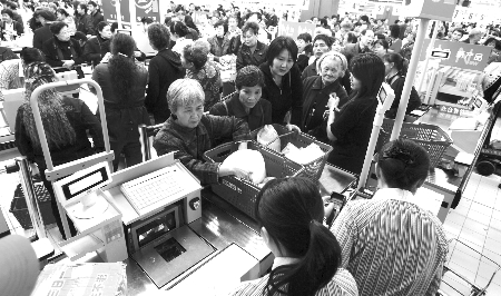 昨日,袁家岗家乐福超市,市民排队在收银台前等待结账 记者 欧阳祖兵