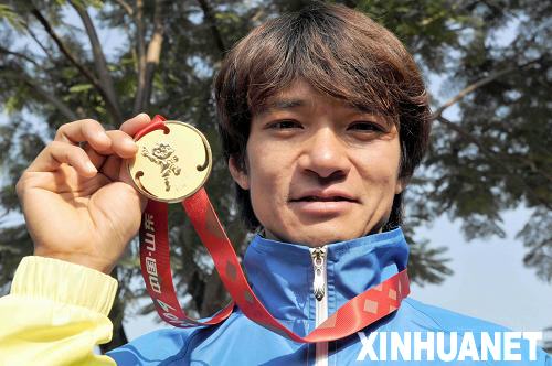 10月27日，香港自行车队队员黄金宝在发布上展示所获得的公路个人赛金牌。新华社记者卢炳辉