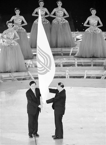 国家体育总局局长刘鹏（右）将全运会会旗交给第十二届全国运动会承办地代表、辽宁省省长陈政高。