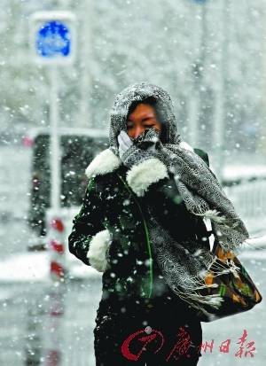 京城鹅毛大雪,路上行人雪中顶风而行. 新华社发