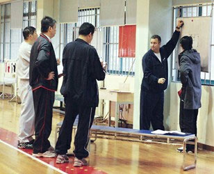走马上任的外教邓华德（右二）训练前与三位上海男篮教练交流战术  彭幼龙