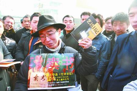 "史上最牛乞丐"夏海波在郑州二七广场叫卖他的自传体书《乞讨日记》