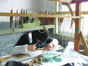 织娘正在制作世博会元首夫人所穿旗袍的缂丝面料.