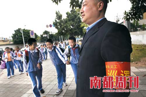 12月9日早上，在南山外国语学校文华部门口东侧，一名第一天上岗的家长义工正在巡逻。