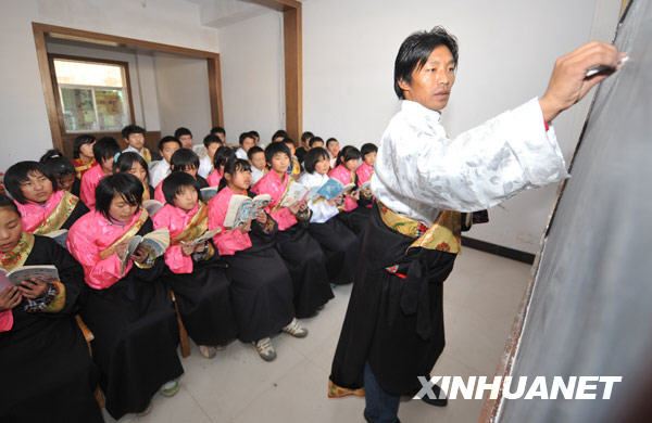 12月17日,在会宁县北关小学读书的藏族学生班马仲格(左)在语文课上