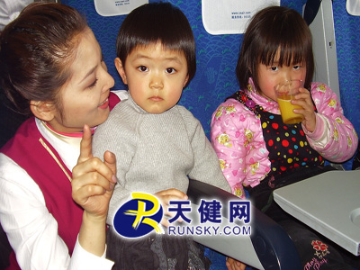 图为2月7日cz6431大连-昆明的航班上,小旅客瞪大眼睛在听乘务员姐姐讲故事