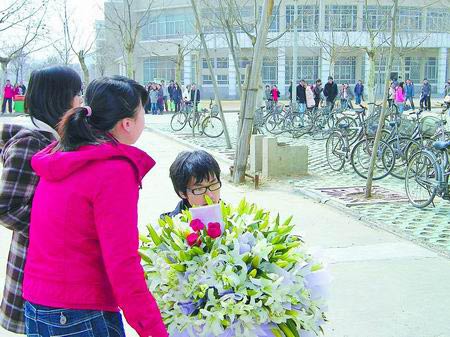 男主角手捧一大束鲜花,单膝跪下向红衣女生求爱.