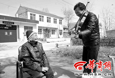 暖暖阳光下听着儿子用小提琴拉出的美妙旋律，91岁的李玉琴老人幸福地笑着 本报记者董国梁摄