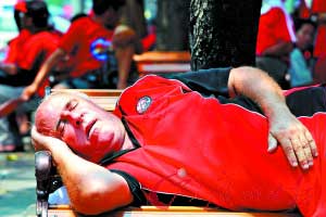 18日,一名外国人穿着"红衫军"的制服睡觉.