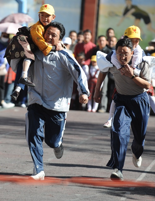 图文:全民健身高原上的运动会 家长背小孩赛跑