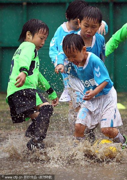 幻灯:韩国儿童享受足球乐趣 泥浆里混战也激情